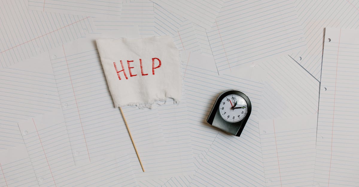 A flat lay image depicting stress and overwork with a help flag and clock on papers.